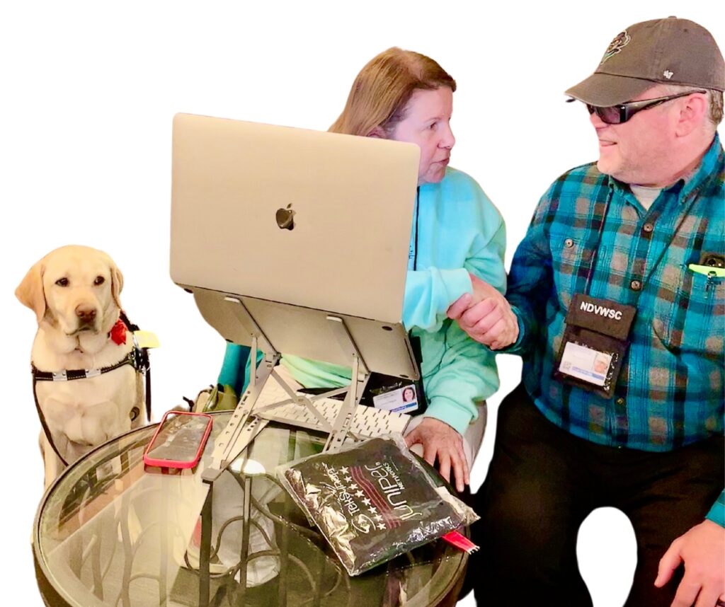Donald (left), a golden lab guide dog, Teresa (middle) behind a laptop looking at Jeffery Hockett (right).