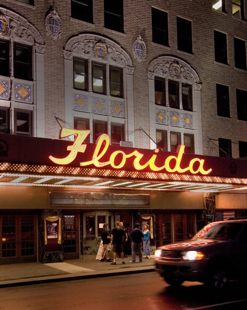 The facade of the Florida Theatre, which is an older bulding with a "Florida" neon light.