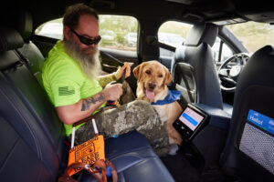 Rob climbs into the backseat of a Waymo Vehicle with his guide dog Kent